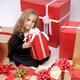 Little girl surrounded by Christmas gifts... (thumbnail)
