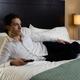 Young Man Lying on a Bed and Watching TV... (thumbnail)
