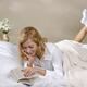 Young Woman Reading in Bed... (thumbnail)