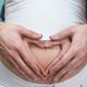 Pregnant Woman with Hands Making Heart Shape on Her Belly... (thumbnail)