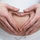 Pregnant Woman with Hands Making Heart Shape on Her Belly... (thumbnail)