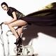 Young Woman in Long Dress on Exercise Bike... (thumbnail)