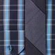 Closeup of a blue tartan shirt with a slim tie... (thumbnail)