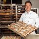 Baker with Freshly Baked Breads on a Tray... (thumbnail)