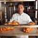 Baker with Freshly Baked Breads on a Tray... (thumbnail)