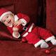 Happy Baby Boy in Santas Costume with a Christmas Bauble... (thumbnail)
