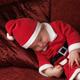 Baby Boy in Santas Costume Sleeping on a Sofa