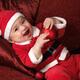 Happy Baby Boy in Santas Costume with a Christmas Bauble