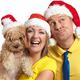 Young Couple with a Dog Wearing Christmas Hats... (thumbnail)