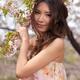 Portrait of a Young Smiling Woman Standing at a Cherry Tree... (thumbnail)