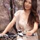 Young Smiling Woman Riding a Bike in a Park... (thumbnail)