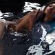 Beautiful black african american woman lying in dark water half naked... (thumbnail)