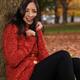 Young Smiling Woman Cuddling in a Sweater in the Wind... (thumbnail)