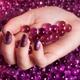 Woman Hand With Purple Nail Polish on Candy... (thumbnail)