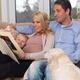 Happy Family with Pregnant Mother Watching Photo Album... (thumbnail)