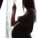 Smiling Pregnant Woman Standing at a Window... (thumbnail)