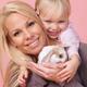 Smiling mother and daughter with a bunny... (thumbnail)