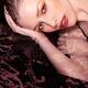 Beauty portrait of a woman wearing makeup and red lipstick lying in wa... (thumbnail)