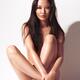 Beautiful asian woman sitting in front of white wall... (thumbnail)