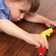 Child playing with a toy train on the floor... (thumbnail)