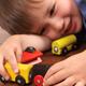 Smiling young boy plaing with a toy train... (thumbnail)