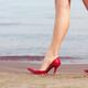 Woman walking in sexy high heel shoes on a sandy beach... (thumbnail)