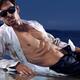 Young man in wet dirty shirt lying on a shore... (thumbnail)