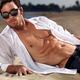 Sexy young man eith bare torso lying on sand at the beach... (thumbnail)