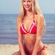 Smiling young woman in red bikini at the beach... (thumbnail)
