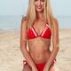 Smiling young woman in red swimsuit at the beach... (thumbnail)