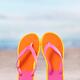 Pair of bright orange flip flops at the beach... (thumbnail)