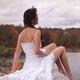 Young woman sitting on a rock near a lake... (thumbnail)