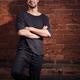 Portrait of a smiling young man at brick wall... (thumbnail)