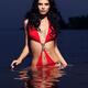Beautiful woman in red swimsuit walking out of water... (thumbnail)