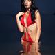 Beautiful woman in red bathing suit standing in water... (thumbnail)