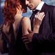 Young man and woman embracing in front of window... (thumbnail)