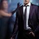 Young man in a suit with a gun in his hand and woman behind glass. Dra... (thumbnail)