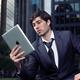 Young businessman with Apple iPad in a city... (thumbnail)
