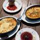 Lasagna and casserole dish with dessert on table... (thumbnail)