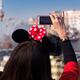 Woman taking pictures with iPhone of show at Tokyo Disneysea... (thumbnail)