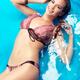 Smiling young woman in bikini lying in water... (thumbnail)