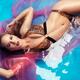 Swimsuit glamour portrait of a beautiful woman in bikini lying in colo... (thumbnail)