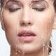 Photo of Water pouring over beautiful woman face with waterproof