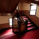 Antique wooden staircase with red carpet... (thumbnail)