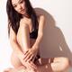 Sexy Japanese woman in bikini sitting against white wall... (thumbnail)