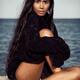 Young beautiful woman in black sweater sitting at the beach... (thumbnail)