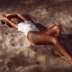 Sexy young woman lying on beach sand at night... (thumbnail)