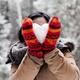 Young woman holding heart made of snow in her hands... (thumbnail)