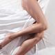 Bare legs of a young woman sleeping naked in bed... (thumbnail)