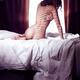 Beautiful nude woman sitting naked on bed back view... (thumbnail)